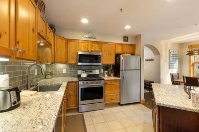 a kitchen with wooden cabinets and stainless steel appliances at 8767 Trappers Crossing condo in Keystone