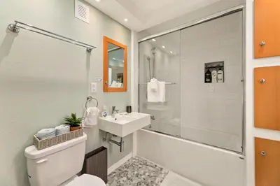 a bathroom with a toilet and a sink and a shower at Vibrant Downtown Bungalow - Walk Everywhere! in Fort Collins