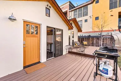 a house with a wooden deck with a grill on it at Vibrant Downtown Bungalow - Walk Everywhere! in Fort Collins