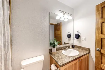 a bathroom with a sink and a toilet and a mirror at Fraser Fantasy in Fraser