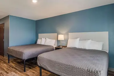 two beds in a room with blue walls at WoodSpring Suites Broomfield-Westminster in Broomfield