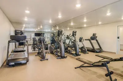 a gym with a bunch of exercise bikes and mirrors at WoodSpring Suites Broomfield-Westminster in Broomfield