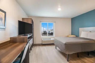 a bedroom with a bed and a flat screen tv at WoodSpring Suites Broomfield-Westminster in Broomfield