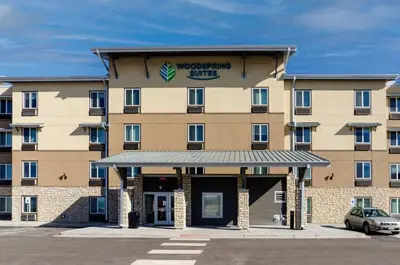 a hotel building with a car parked in a parking lot at WoodSpring Suites Broomfield-Westminster in Broomfield