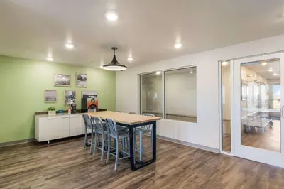 a kitchen and dining room with a table and chairs at WoodSpring Suites Broomfield-Westminster in Broomfield