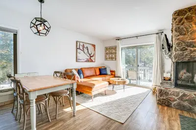 a living room with a couch and a table at Condo with Balcony and Views - Steps to Ski Shuttle! in Fraser