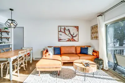 a living room with a couch and a table at Condo with Balcony and Views - Steps to Ski Shuttle! in Fraser