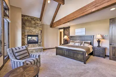 a large bedroom with a bed and a chair at 3 Fireplaces and Mtn View Luxe Home in Breckenridge in Breckenridge