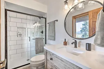 a bathroom with a toilet and a sink and a mirror at Sunny Alpine Escape with Hot Tub and Mountain Vistas! in Fraser
