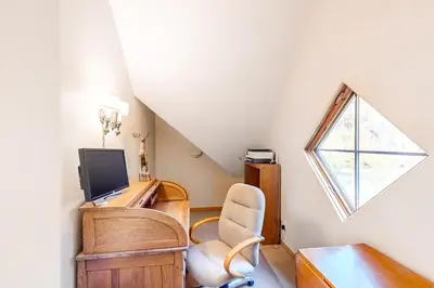 a room with a chair and a tv and a window at Crescent Moon Sanctuary in Silverthorne