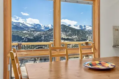 a dining room with a table and a view of mountains at Solitude Vacation Home at Windcliff home in Estes Park