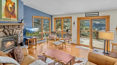 a living room with a fireplace and a tv at Solitude Vacation Home at Windcliff home in Estes Park