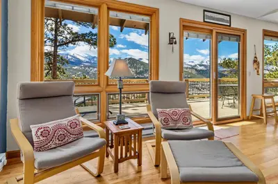 two chairs and a table in a room with windows at Solitude Vacation Home at Windcliff home in Estes Park