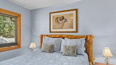 a bedroom with a bed and a picture of a dog at Solitude Vacation Home at Windcliff home in Estes Park