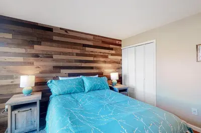 a bedroom with a wooden accent wall and a bed at Wildernest Rest in Silverthorne