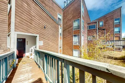 a building with a balcony and a red door at Wildernest Rest in Silverthorne