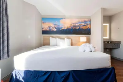 a large white bed with a stuffed elephant on it at Days Inn by Wyndham Thornton in Thornton