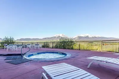 a hot tub on a patio with mountains in the background at Comfort Suites Summit County in Dillon