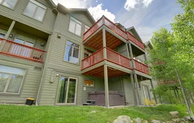 a green house with red balconies on it at Prospector Point E 4Br 3,5Ba townhouse in Frisco