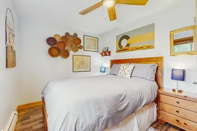 a bedroom with a bed and a wooden dresser at Hi Country Haus 14-5 in Winter Park