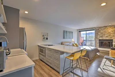 a kitchen with a bed and a kitchen island with chairs at Walk to Main St Frisco! Modern Unit 7 Mi to Slopes in Frisco