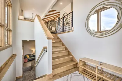 a circular mirror hangs above a staircase in a house at 13 Mi to Slopes! Silverthorne Home with Pool Access in Silverthorne