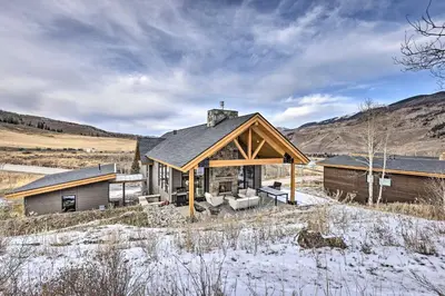 a house with a large roof on a snowy field at 13 Mi to Slopes! Silverthorne Home with Pool Access in Silverthorne
