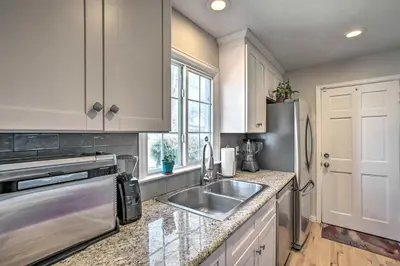 a kitchen with a sink and a refrigerator at Centrally Located Aurora Home with Covered Patio in Aurora