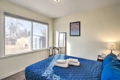 a bedroom with a blue bed and a large window at Centrally Located Aurora Home with Covered Patio in Aurora