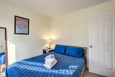 a bedroom with a blue bed with towels on it at Centrally Located Aurora Home with Covered Patio in Aurora