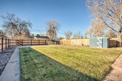 a backyard with a fence and a yard withgrass at Centrally Located Aurora Home with Covered Patio in Aurora