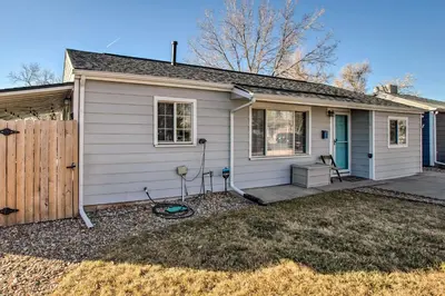 a small white house with a wooden fence at Centrally Located Aurora Home with Covered Patio in Aurora