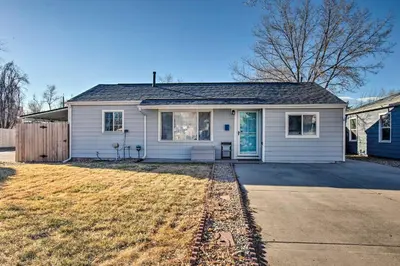 a white house with a driveway in front of it at Centrally Located Aurora Home with Covered Patio in Aurora