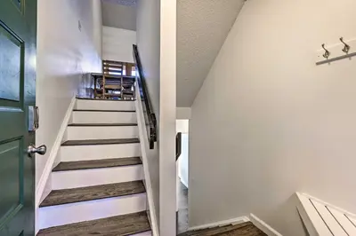 a staircase in a house with a green door at Hot Tub and Mtn Views Silverthorne Escape! in Silverthorne