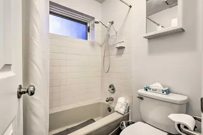 a white bathroom with a toilet and a bath tub at Hot Tub and Mtn Views Silverthorne Escape! in Silverthorne