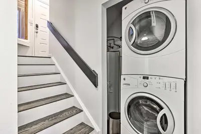 a laundry room with a washer and dryer next to a staircase at Hot Tub and Mtn Views Silverthorne Escape! in Silverthorne