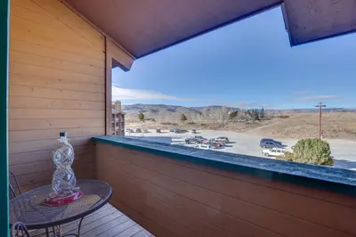 a glass bottle on a table on a balcony with a view at 2 Mi to Granby Ranch Resort Studio with Pool Access in Granby