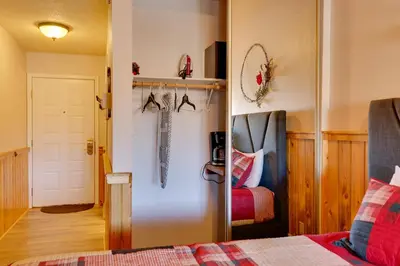 a room with a bed and a door with an umbrella at 2 Mi to Granby Ranch Resort Studio with Pool Access in Granby