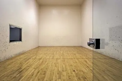 an empty room with a television and a wooden floor at 2 Mi to Granby Ranch Resort Studio with Pool Access in Granby