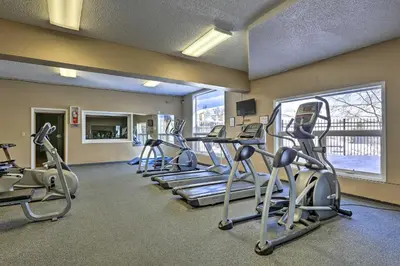 a gym with several treadmills and a row of exercise bikes at 2 Mi to Skiing Studio with Pool Access in Granby! in Granby