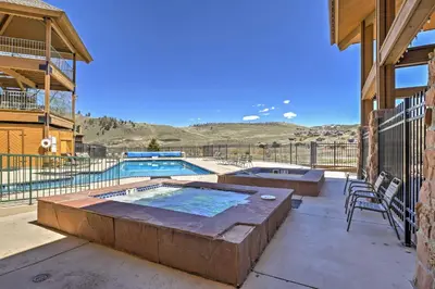 a patio with a pool and a table and chairs at 2 Mi to Skiing Studio with Pool Access in Granby! in Granby