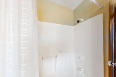 a white bathroom with a shower and a toilet at At the Crossroads in Frisco