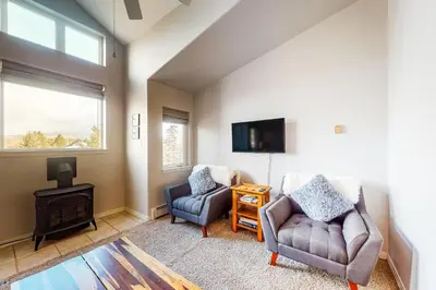 a living room with two chairs and a tv at At the Crossroads in Frisco
