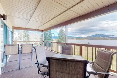 a screened porch with chairs and a table with a view of a lake at Lakeside Mountain Retreat in Dillon