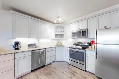 a kitchen with white cabinets and a stainless steel refrigerator at Lakeside Mountain Retreat in Dillon