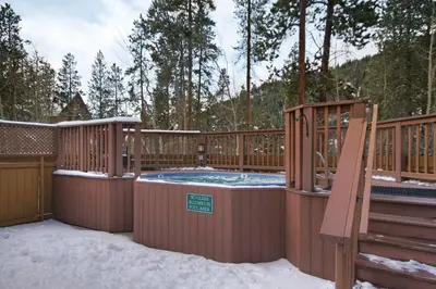 a hot tub on a deck with snow on the ground at 8758 Trappers Crossing condo in Dillon