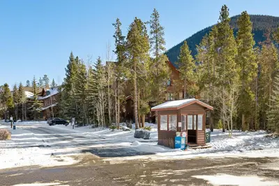 a small bus stop in the snow next to a road at 8758 Trappers Crossing condo in Dillon