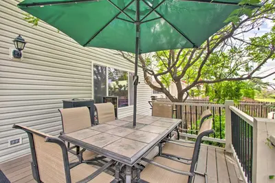 a table and chairs with an umbrella on a deck at Green Valley Ranch - Family Home 13 Mins to DIA in Denver