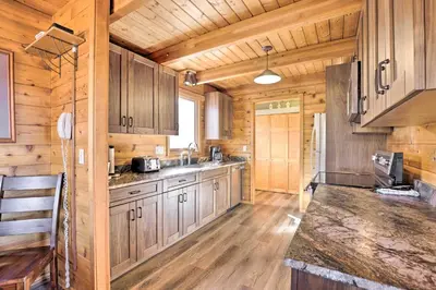 a kitchen with wooden cabinets and a counter top at 1 Mi to Granby Ranch Family-Friendly Cabin! in Granby