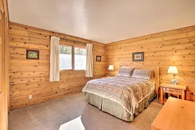 a bedroom with wooden walls and a bed and a window at 1 Mi to Granby Ranch Family-Friendly Cabin! in Granby